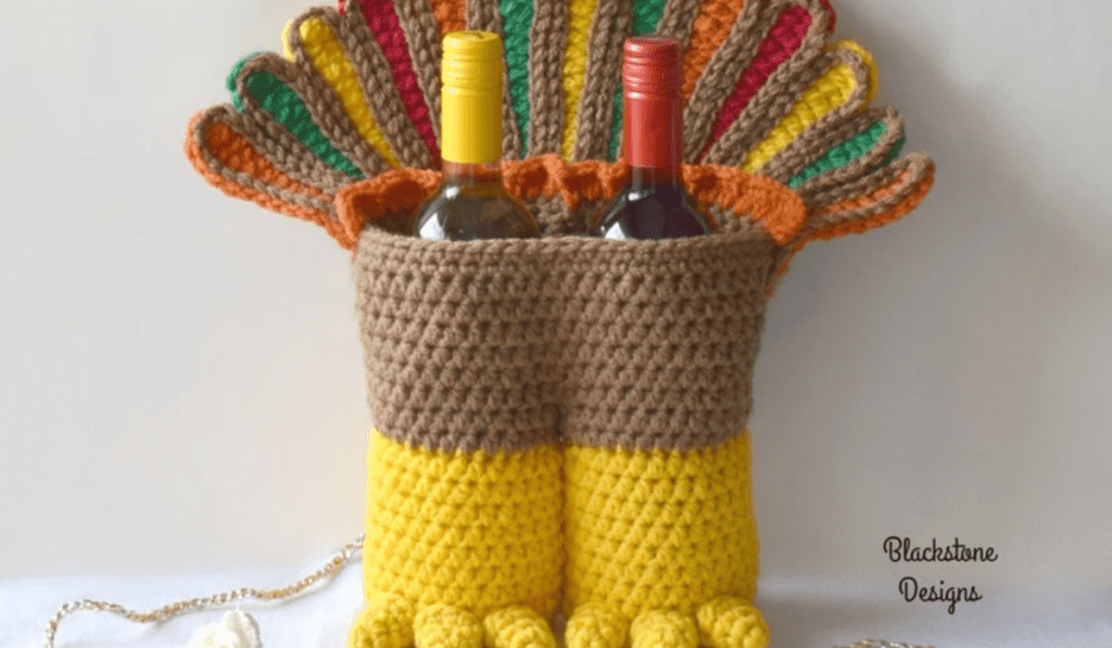 A crochet turkey legs basket with two wine bottles inside.