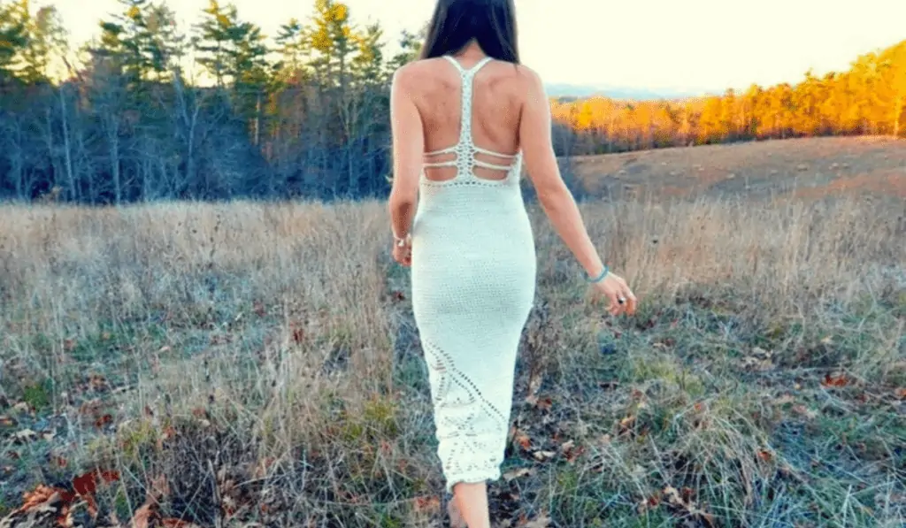 A white tight dress with detailing on the back that looks like racerback style.