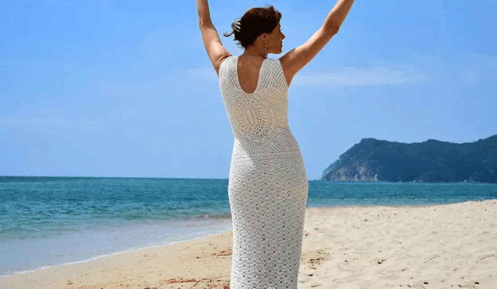 A crochet wedding dress with a large mandala design on the back.