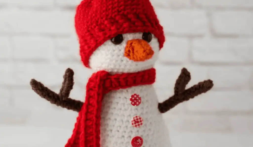 Crochet snowman with red hat and scarf.