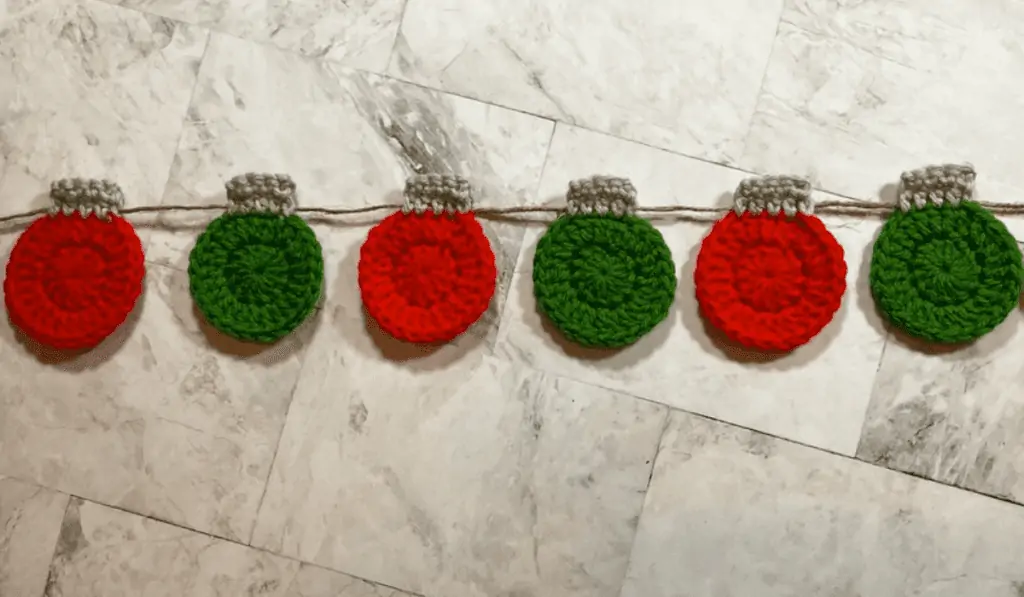 A string of 2D crocheted ornaments on a garland.