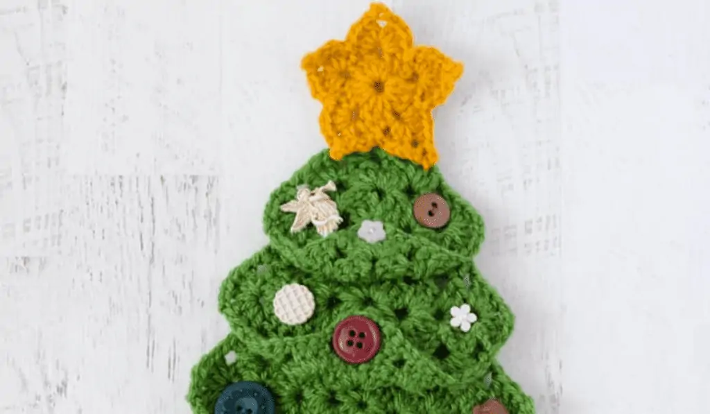 Granny square christmas tree with a star at the top and many little buttons to look like ornaments.