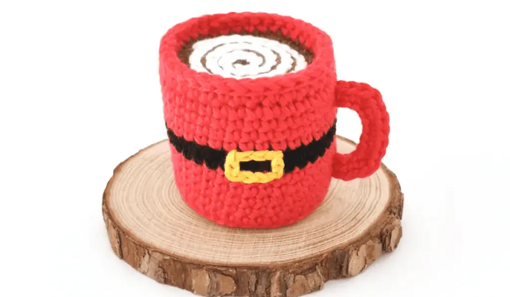 A crochet mug with hot chocolate on the inside.