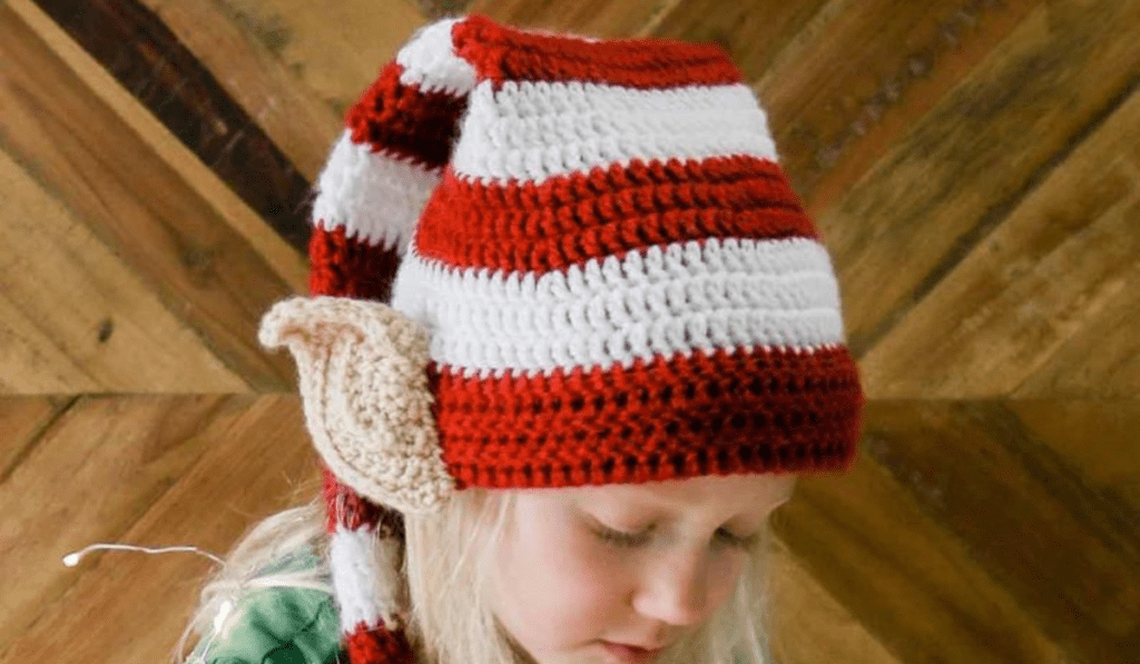 A long red and white striped elf hat with crochet elf ears.