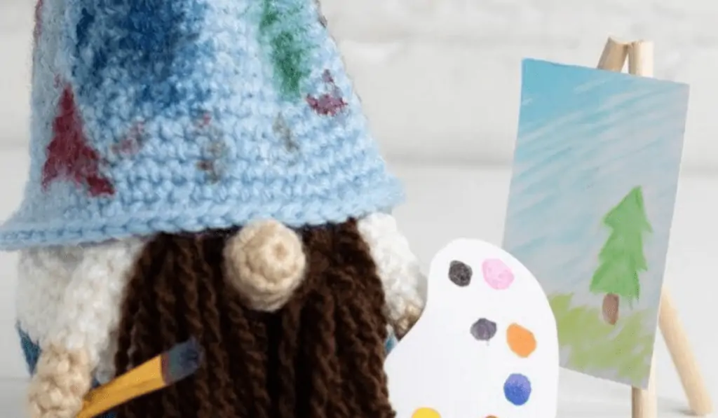 crochet painter gnome with canvas, paints, and paintbrush