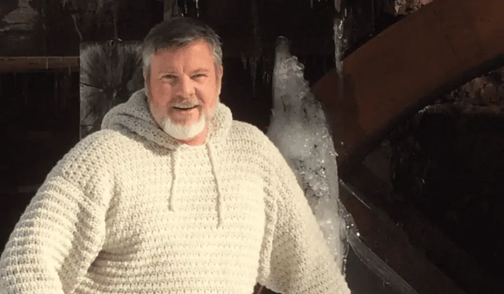 A man wearing a white crochet hoodie.