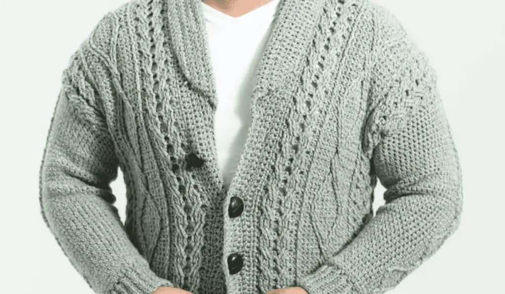 A cable knit-looking crochet sweater in seafoam green yarn.
