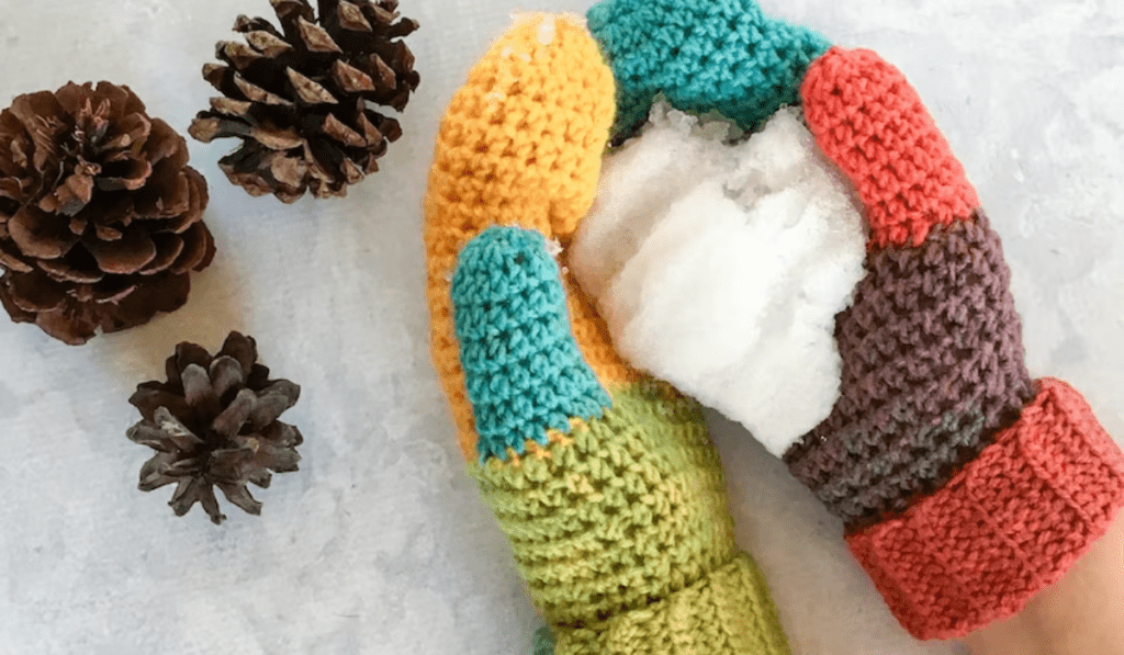 Color block crochet mittens that includes yellow, blue, green, pink, and purple yarn.