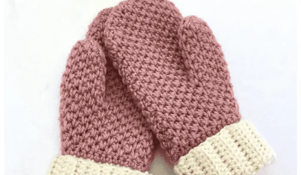 Pink crochet mittens with white cuffs.