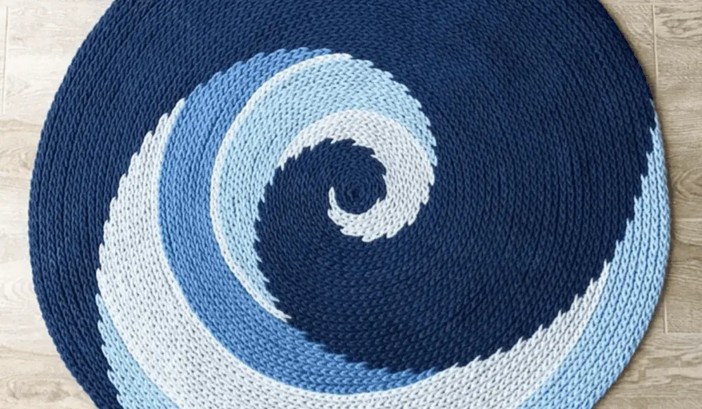 A circular crochet rug with a wave design.