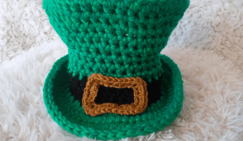 A green crocheted leprechaun hat with a gold buckle.