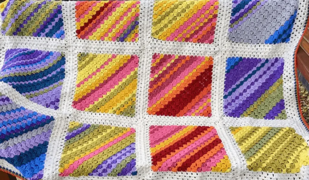 A crochet blanket with different squares showing the temperature of that day.