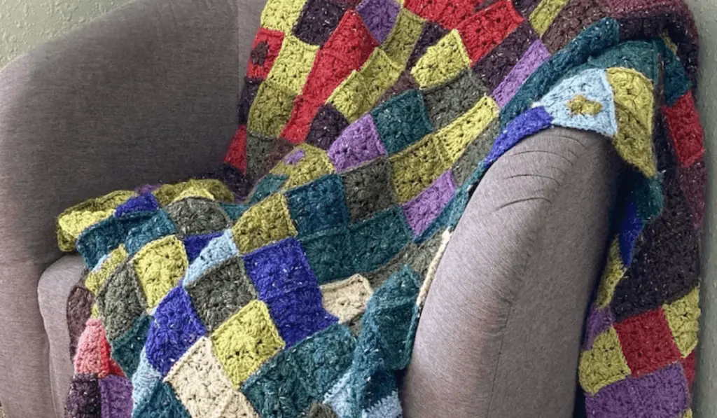 A crochet temperature blanket with mini squares in different colors