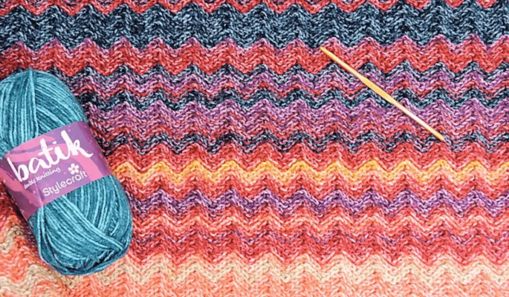 A crochet temperature blanket with zig zag rows