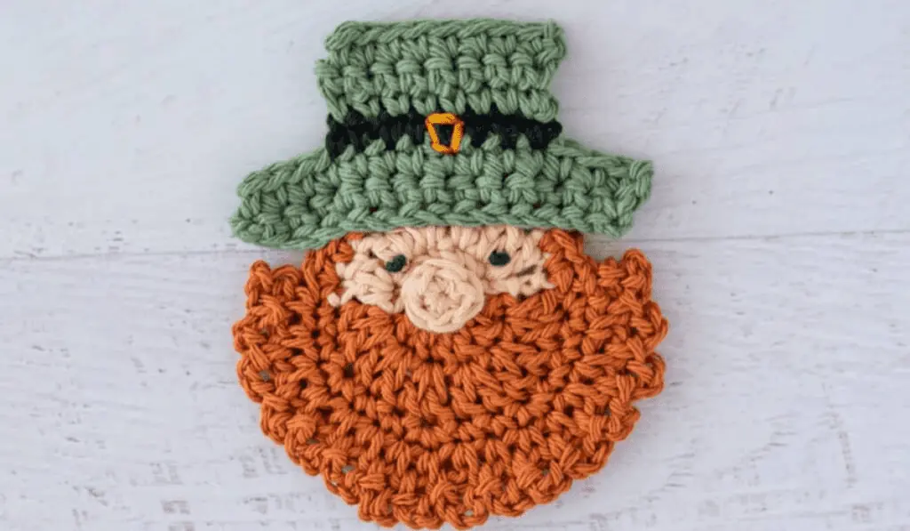 A crocheted coaster that looks like a leprechaun head.