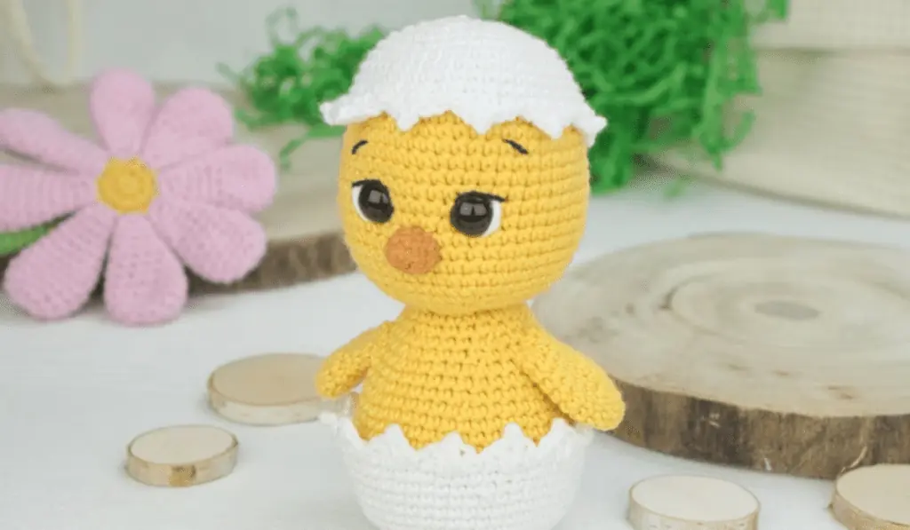 A amigurumi chick coming out of a cracked egg
