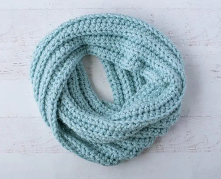 Blue ribbed crochet scarf displayed in a circle