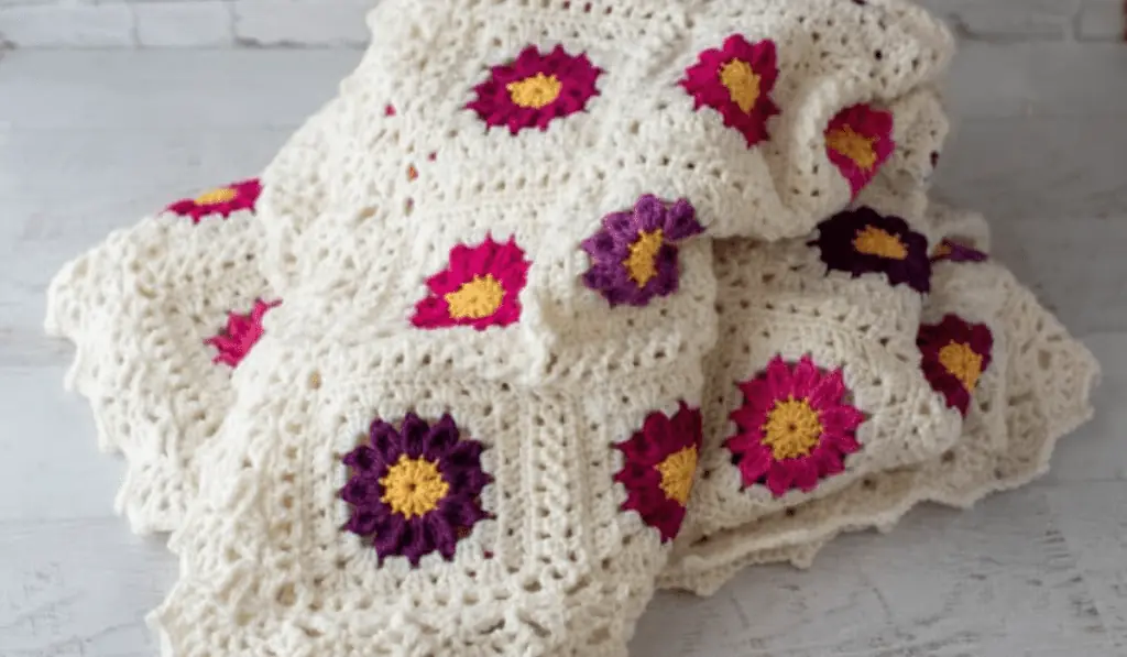 Crochet afghan with purple and pink flowers