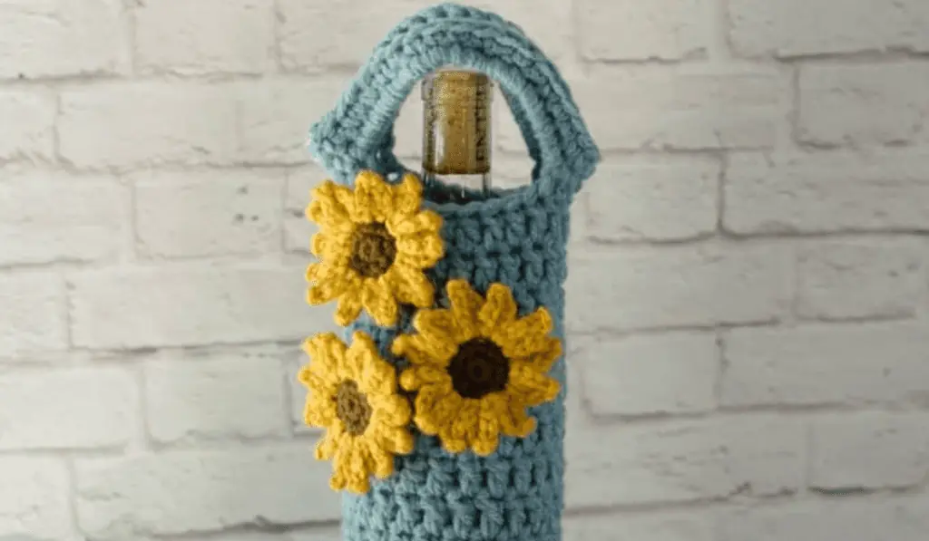 A blue wine cozy with three sunflowers