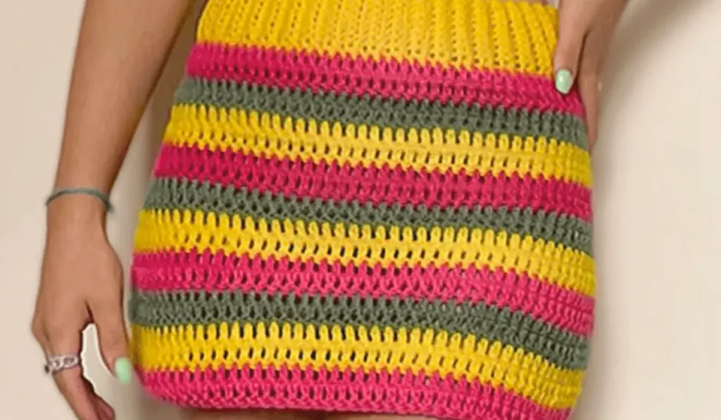 Crochet striped mini skirt with yellow, red, and green yarn.