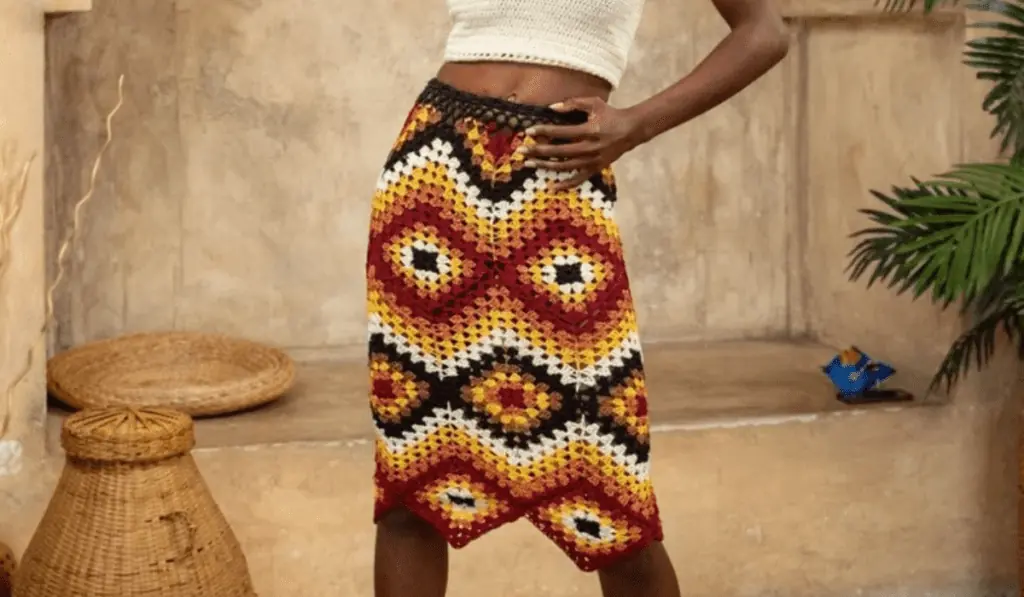 A crochet midi skirt with diamond of red, yellow, white, black, and brown yarn.