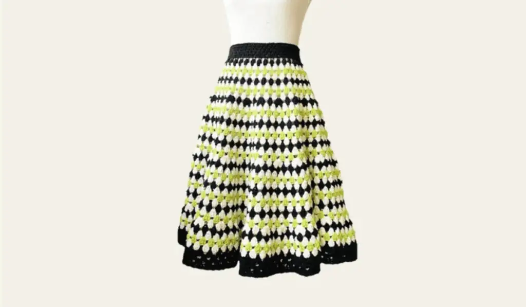 A retro-looking crochet midi skirt with rows of black, white, and green yarn.
