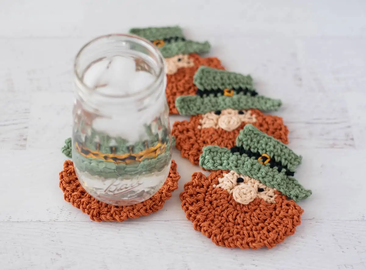 St Patricks Day Crochet Coasters, 4 leprechaun crochet coasters in a spiral with a glass of water