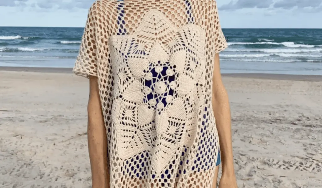 A mesh-style beach cover-up that mainly features a flower design on the front.