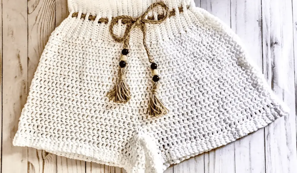 White crochet shorts with a brown drawstring.