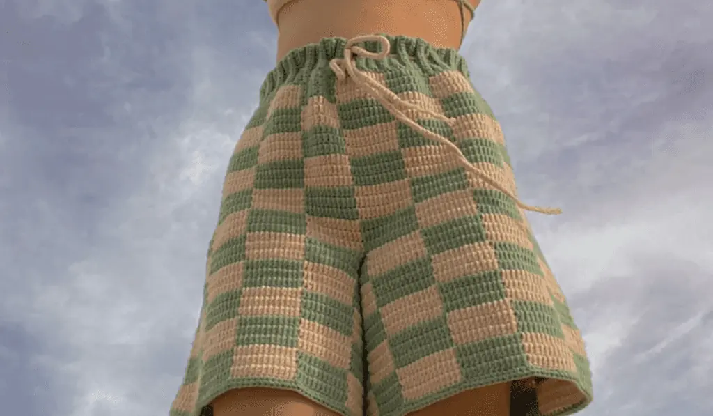 Checkered crochet shorts that are green and off-white.