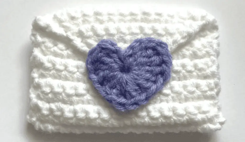 An envelop crochet gift card holder with a purple closure.