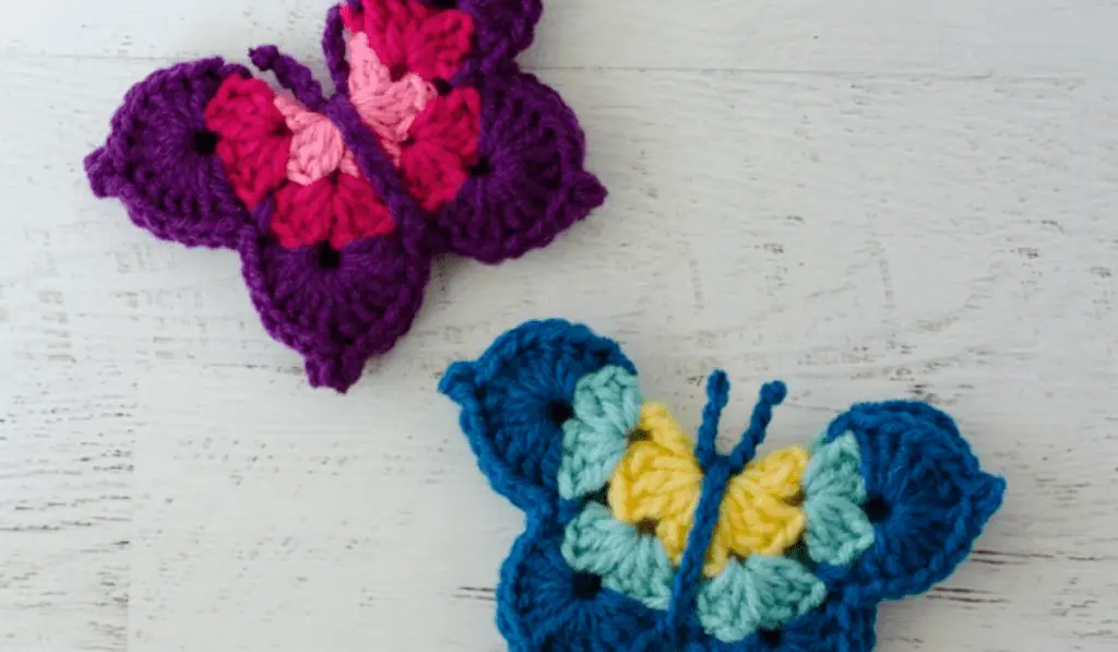 Two butterfly appliques, one is purple and pink, one is blue and yellow.
