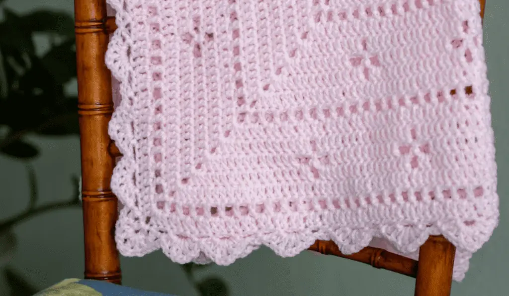 A pink airy crochet baby blanket