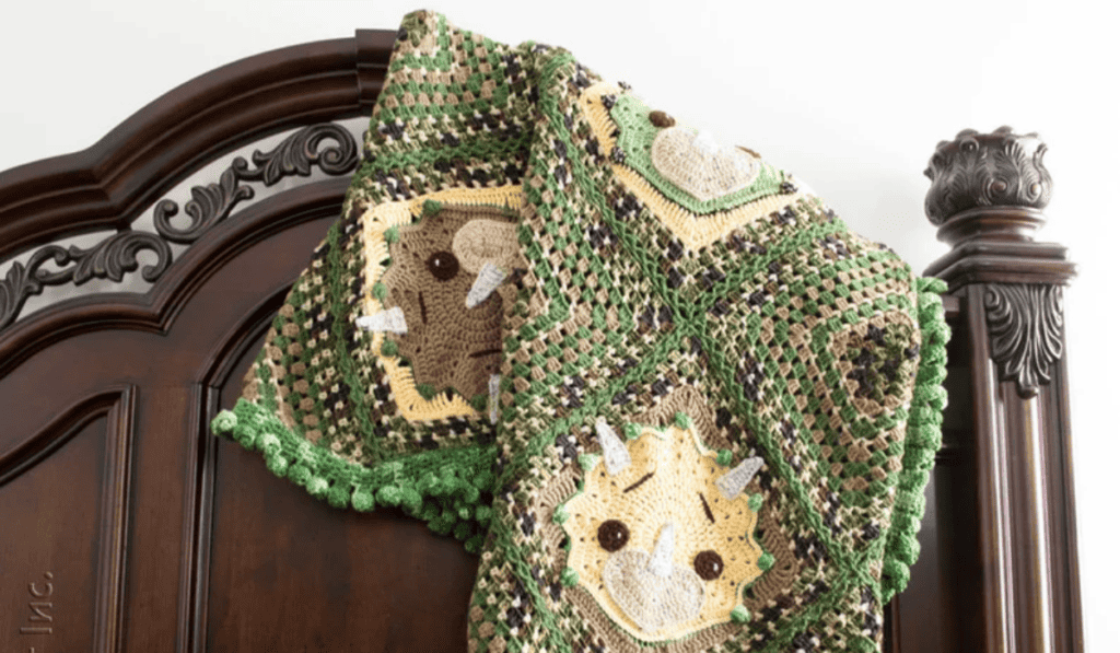 A green and brown dinosaur blanket