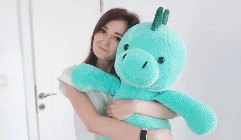 A large blue crochet dinosaur