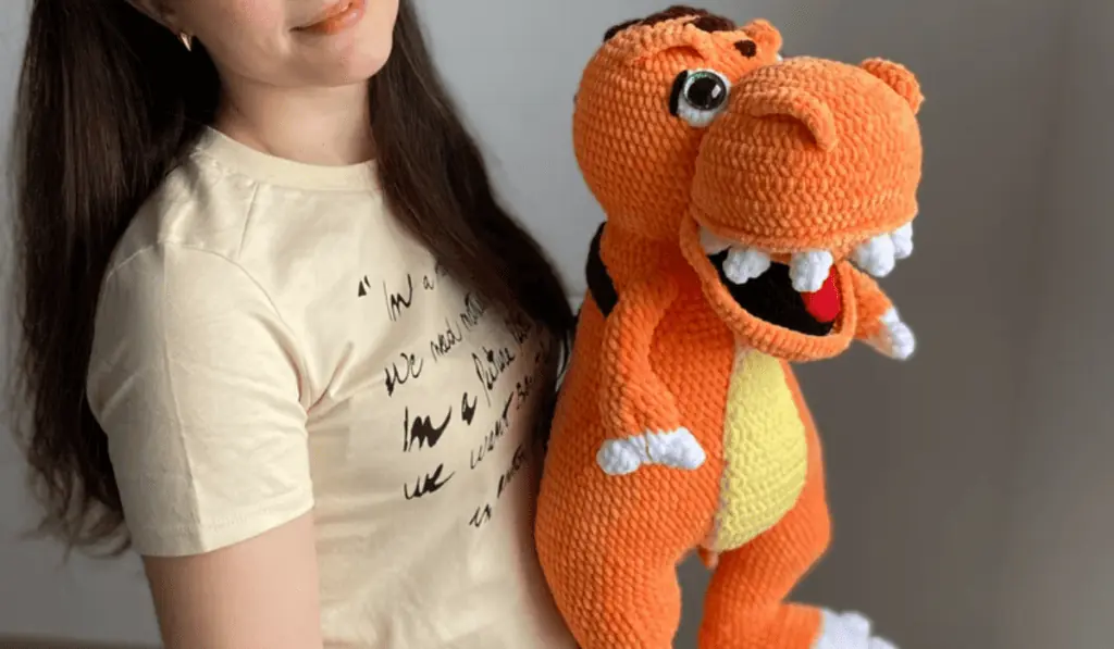 An orange crochet t-rex