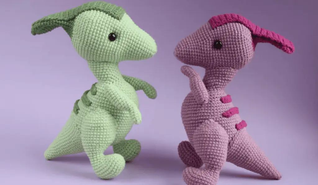 Two crochet dinosaurs, one in green and one in purple