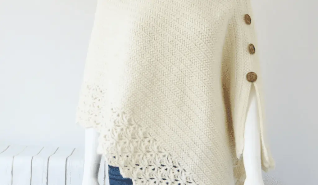 An asymmetrical crochet poncho pattern with lacy detailing at the bottom.