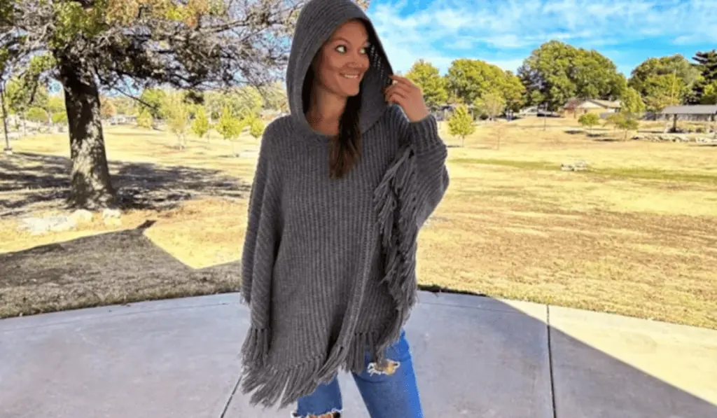 A grey crochet poncho pattern with a hood and fringe along the bottom.