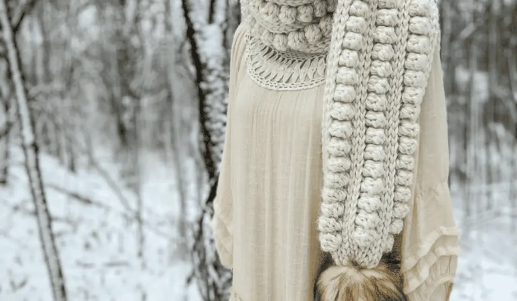 A crochet bobble scarf with a fur circle at the bottom.