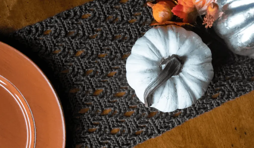 A black crochet table runner in a wavy design.