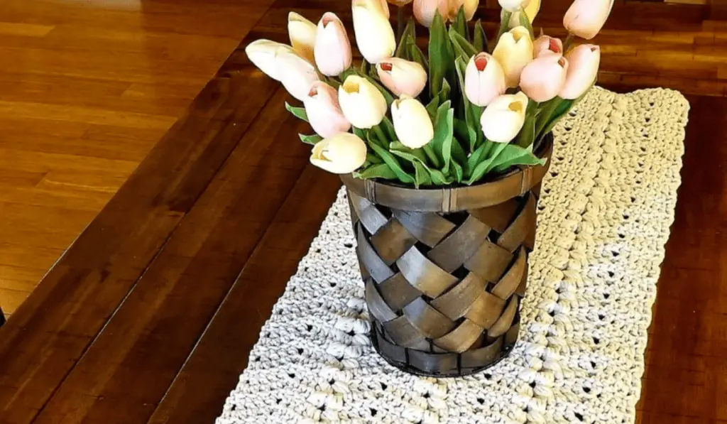 An all white crochet table runner in a long rectangle