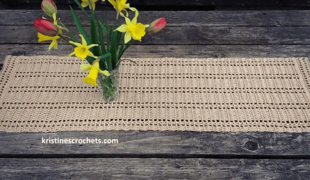 A beige crochet table runner