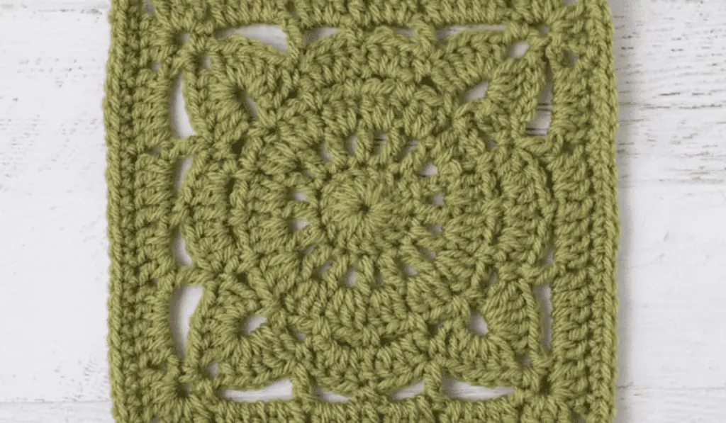 A granny square made out of green yarn.