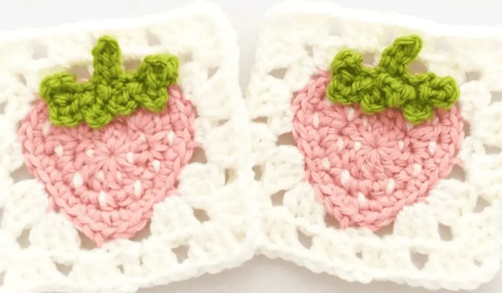 Two strawberry granny squares with white borders.