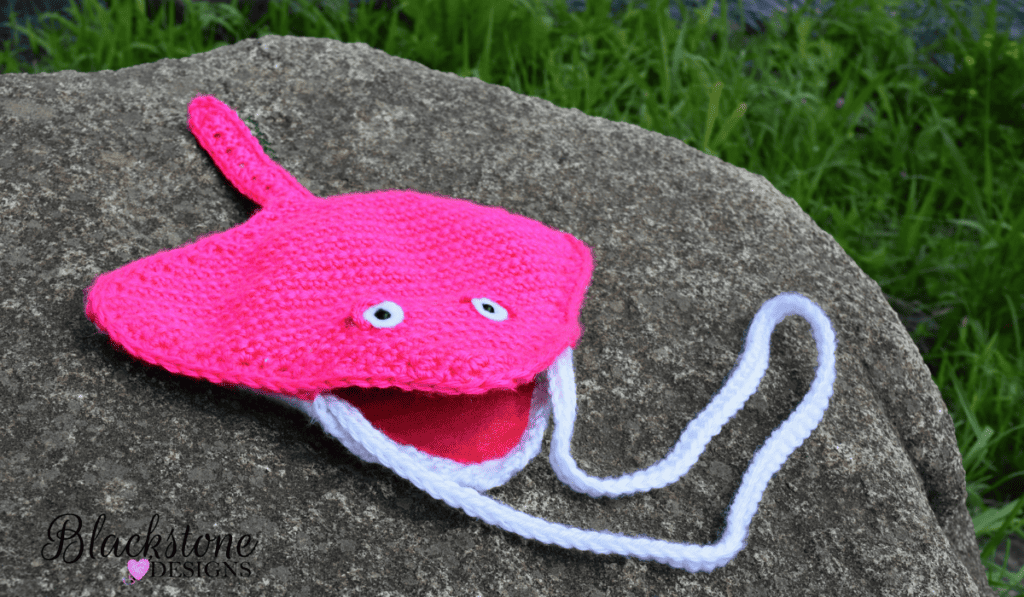 A pink crochet stingray crossbody bag.