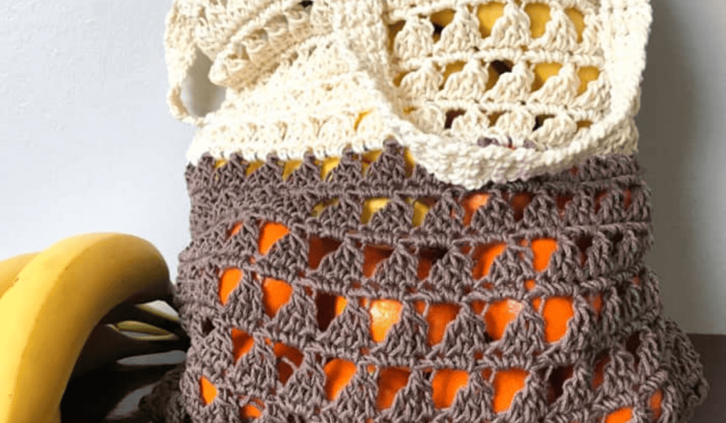 A crochet market bag with two different colors, the top is white and the bottom is brown.