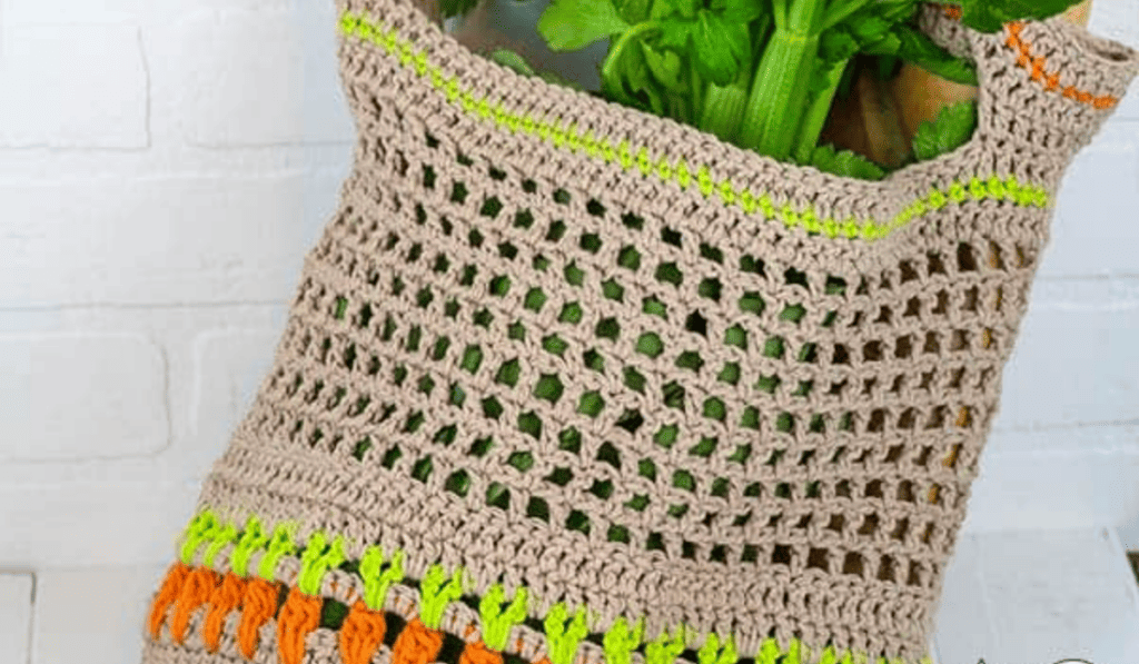 A crochet market bag with a row of stitches along the bottom that looks like carrots.