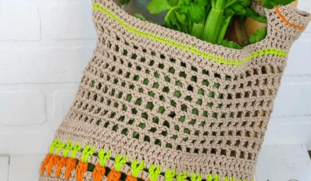 A crochet market bag with a row of stitches along the bottom that looks like carrots.