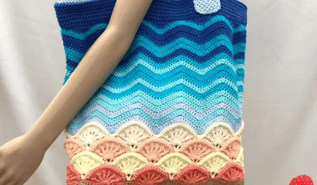 A wavy design crochet tote bag that looks like the ocean meeting the sand.
